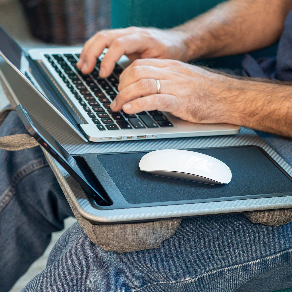 Person sitting in a chair using the Left-Hand Friendly Home Office Lap Desk on their lap, working on a laptop.